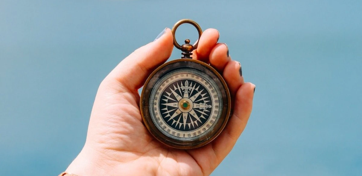 image of a hand holding a compass