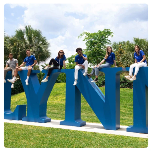 students taking a photo with the Lynn University sign